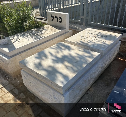 מצבות מאבן טבעית בהירה עם כיתוב מוקפד בבית עלמין